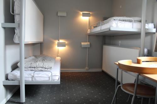 海宁海宁大宿舍酒店的客房设有两张双层床和一张桌子。