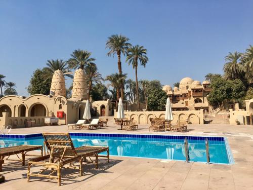 卢克索Djorff Palace的一个带游泳池和棕榈树的度假村