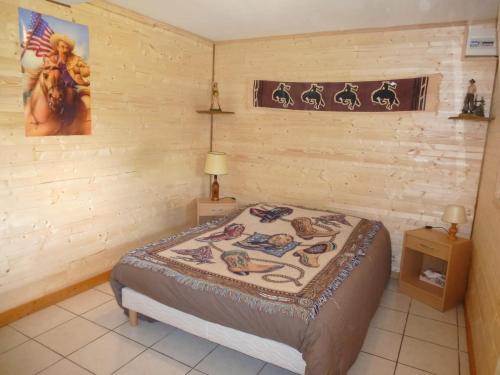 Romilly-sur-AndelleTiny House Westen Life的卧室配有一张床铺,位于带木墙的房间内