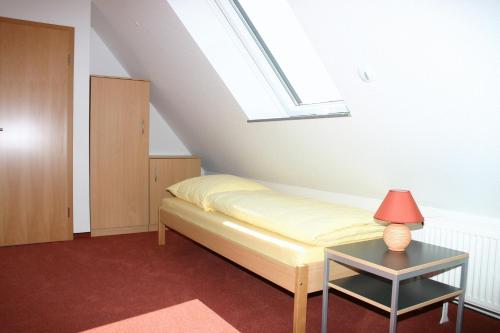 斯图加特达斯公寓酒店的一间卧室配有一张床和一张桌子上的台灯