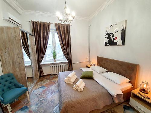 基辅Inn Home Apartments in Kiev Center的一间卧室配有一张大床和蓝色椅子