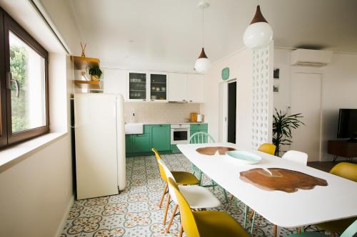 莫什港Eco Villa do Adro的厨房配有白色的桌子和黄色的椅子