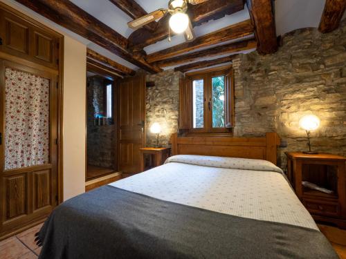 博尔塔纳CASA RURAL CRUZ - Self check-in的一间卧室设有一张床和石墙