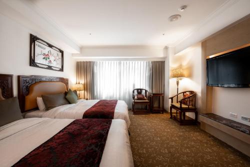 高雄阳光大饭店的酒店客房设有两张床和一台平面电视。
