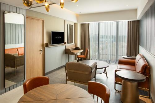 日惹PORTA by Ambarrukmo的酒店客房设有带桌椅的等候区。