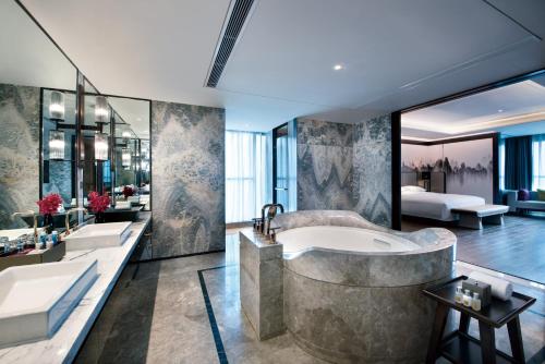 宝鸡宝鸡东岭皇冠假日酒店的浴室配有2个盥洗盆和1个浴缸。