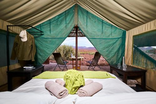 达马拉兰Etendeka Mountain Camp的帐篷内一间卧室,配有一张床