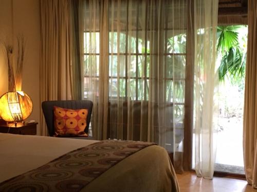 圣卢西亚艾弗里克亚宾馆的卧室配有床、椅子和窗户。
