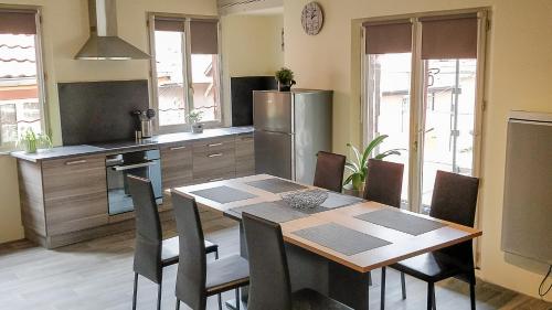 坎特赞Le Familial的厨房配有桌椅和冰箱。