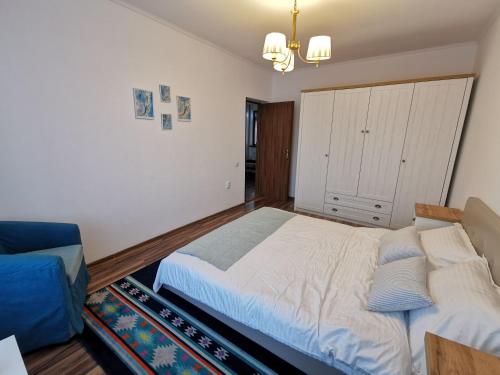 雅西Charming apartment in villa的一间卧室配有一张大床和一张蓝色的沙发