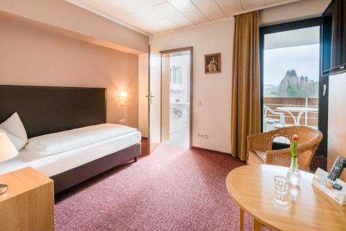 DeudesfeldPension Haus Anny的酒店客房配有一张床铺和一张桌子。