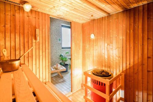 DeudesfeldPension Haus Anny的一间带木墙和木楼梯的桑拿浴室