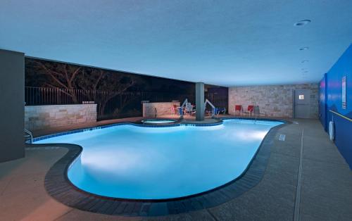 福朋奥斯汀西北智选假日套房酒店 - 四点的一座拥有蓝色灯光的大型游泳池