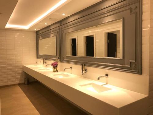 拉合尔尼莎乔哈尔镇酒店的浴室设有3个水槽和2面镜子