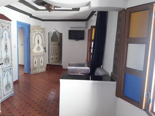 舍夫沙万Casa El Haouta的走廊上设有门和地板的房间