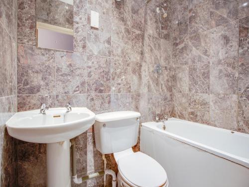 伦敦OYO Somerset Hotel Baker Street London的浴室配有盥洗盆、卫生间和浴缸。