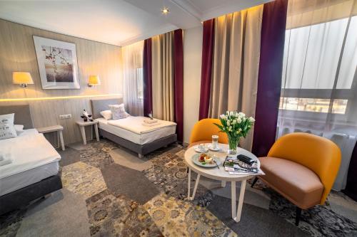 卢布林维多利亚酒店的酒店客房带一张床、一张桌子和椅子