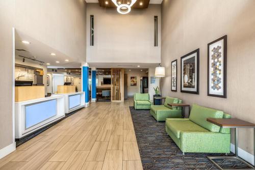 弗里蒙特弗里蒙特米尔皮塔斯中心快捷假日酒店的医院的大堂,设有绿色椅子和厨房