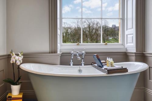 巴克斯顿Ensana Buxton Crescent的窗户客房内的白色浴缸