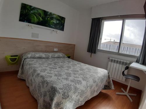 圣地亚哥－德孔波斯特拉Rey Fernando的一间卧室设有一张床和一个大窗户