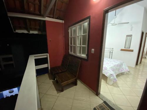佩尼多Chalé Condominio Linda Vista的一间设有楼梯的房间和一间带一张床的卧室