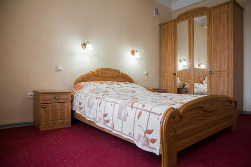 基希讷乌基希讷乌酒店的一间卧室配有木床和木制梳妆台