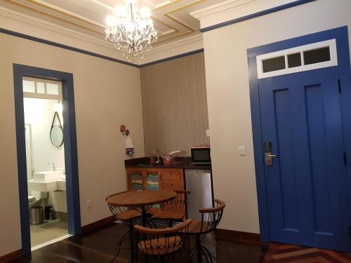 欧鲁普雷图Suite Família Inconfidentes的一间设有蓝色门、一张桌子和椅子的房间