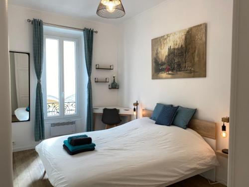 尼斯Chic and Cosy apartment close to the port and Garibaldi的卧室配有带蓝色枕头的大型白色床
