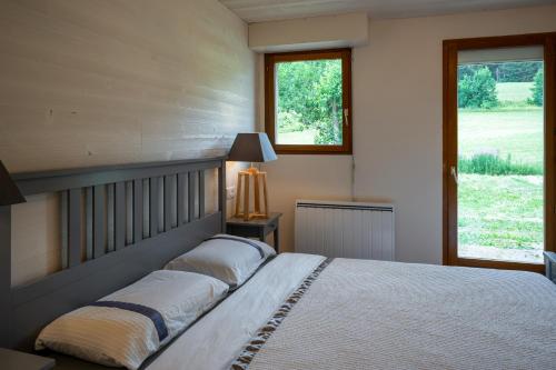 拉穆拉Le Refuge的一间卧室设有一张大床和两个窗户。