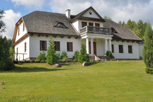 苏普拉希尔Dworek Lipowy Most的一座大型白色房子,设有大院子