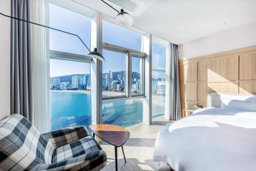 釜山H Avenue Gwanganri Beach的酒店客房设有一张床和一个大窗户