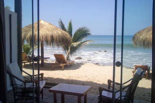 卡诺阿斯德蓬萨尔Baja Canoas Hotel的享有海滩美景,配有椅子和桌子