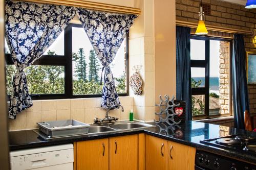 阿曼济姆托蒂Seven Seas SA的带水槽的厨房和2扇窗户