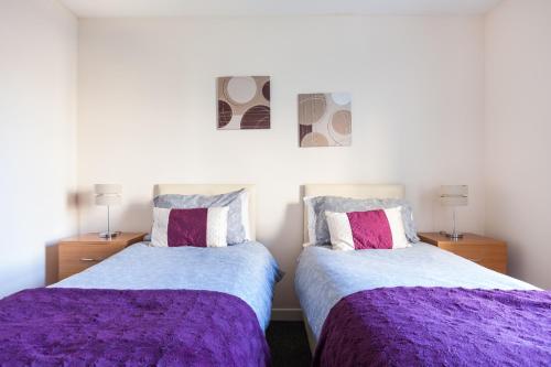阿伯丁City View的卧室内的两张床,配有紫色床单