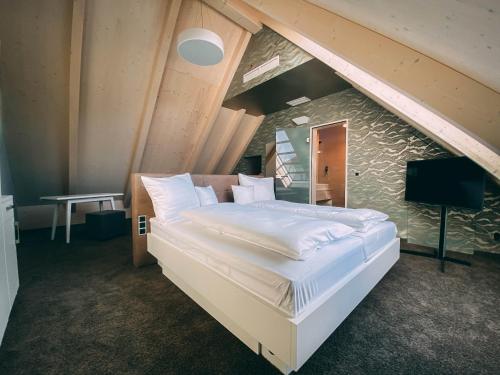 金齐希谷地哈斯拉赫Stadthotel Haslach的阁楼上的卧室配有一张大床
