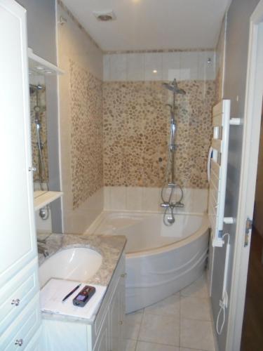 阿罗芒什莱班le neptune的白色的浴室设有浴缸和水槽。