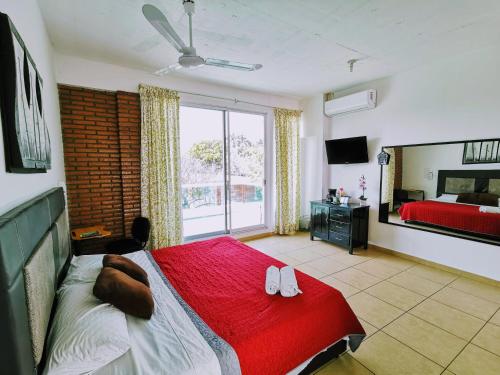 图斯特拉古铁雷斯La Terraza的一间卧室设有红色的床和大窗户