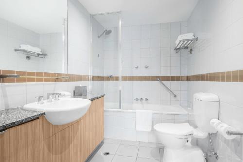 墨尔本曼特拉罗素酒店的浴室配有盥洗盆、卫生间和浴缸。