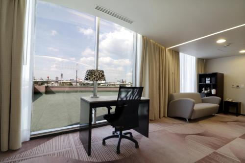 墨西哥城墨西哥美迪加苏尔智选假日套房酒店的客房设有书桌、椅子和窗户。