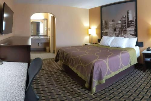 休斯顿Super 8 by Wyndham Houston/Willowbrook Hwy 249的酒店客房设有床和水槽