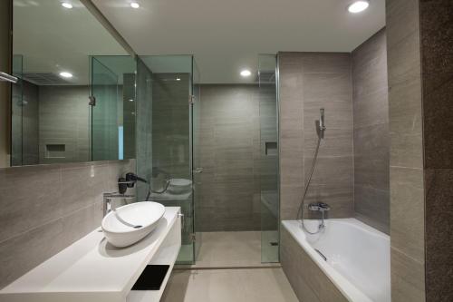 邦加槟港Grand Safran Hotel Pangkalpinang的浴室配有盥洗盆、卫生间和浴缸。