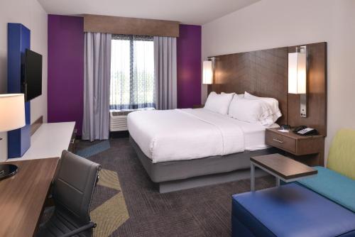 布赖恩特Holiday Inn Express and Suites Bryant - Benton Area, an IHG Hotel的酒店客房设有一张大床和一张书桌。
