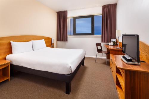 北安普敦宜必思北安普敦中心酒店的酒店客房设有一张床、一张书桌和一台电视机。