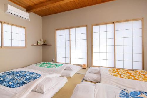 富士吉田市Kitaguchi Tougakukan的带窗户的客房内的三张床