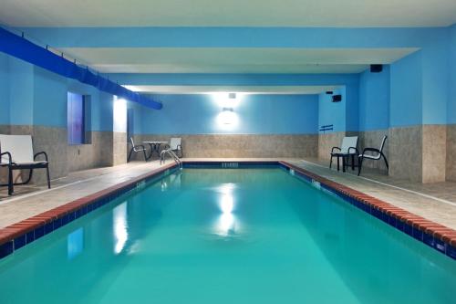 Amite阿米特智选假日酒店的一座带蓝色墙壁和椅子的建筑中的游泳池