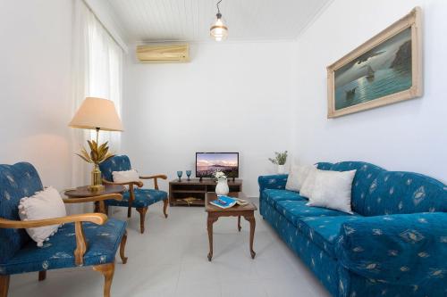 扎金索斯镇Andriani Apartment的客厅配有蓝色的沙发和椅子