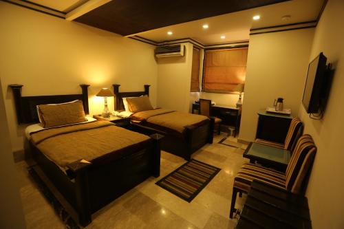 木尔坦City Centre Suites的酒店客房设有两张床和电视。