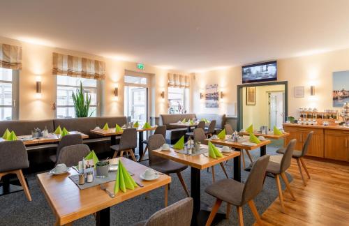 胡苏姆Nordsee-Hotel Hinrichsen的一间带桌椅的餐厅和一间酒吧