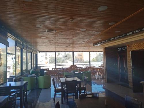 瓦迪穆萨Petra Visitors Apartments的用餐室设有桌椅和窗户。
