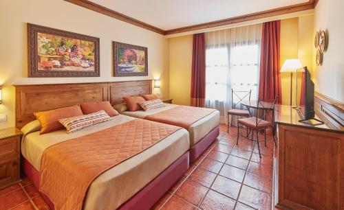 萨洛PortAventura Hotel El Paso - Includes PortAventura Park Tickets的一间卧室配有一张床、一张书桌和一台电视